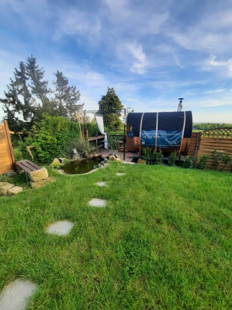 Weg durch den Garten zur mobilen Fasssauna
