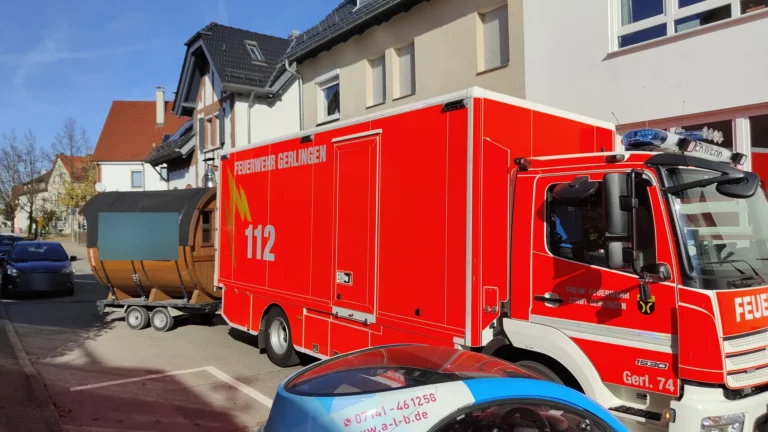 Feuerwehrfahrzeug mit der mobilen Fasssauna im Schlepptau