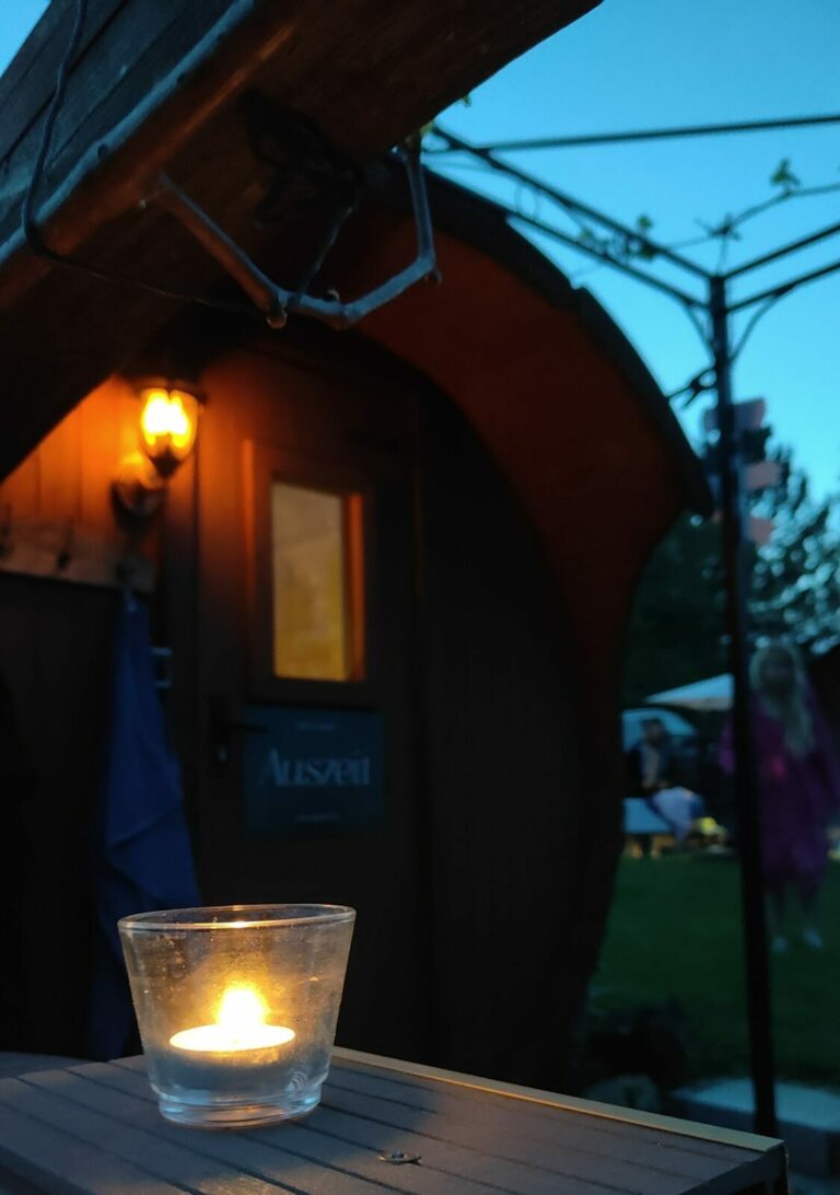 Mobile Fasssauna am Abend mit Kerzenlicht