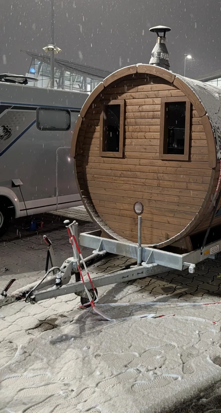 Mobile Fasssauna bei Schneefall auf einem Eventgelände