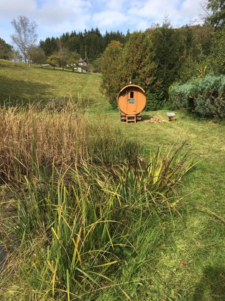 Mobile Fasssauna auf einer Wiese im Herbst