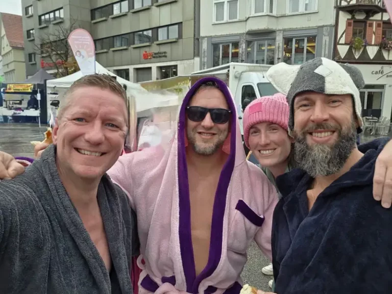 Saunafreunde in Bademänteln beim Charity-Eisbad auf dem Reutlinger Marktplatz